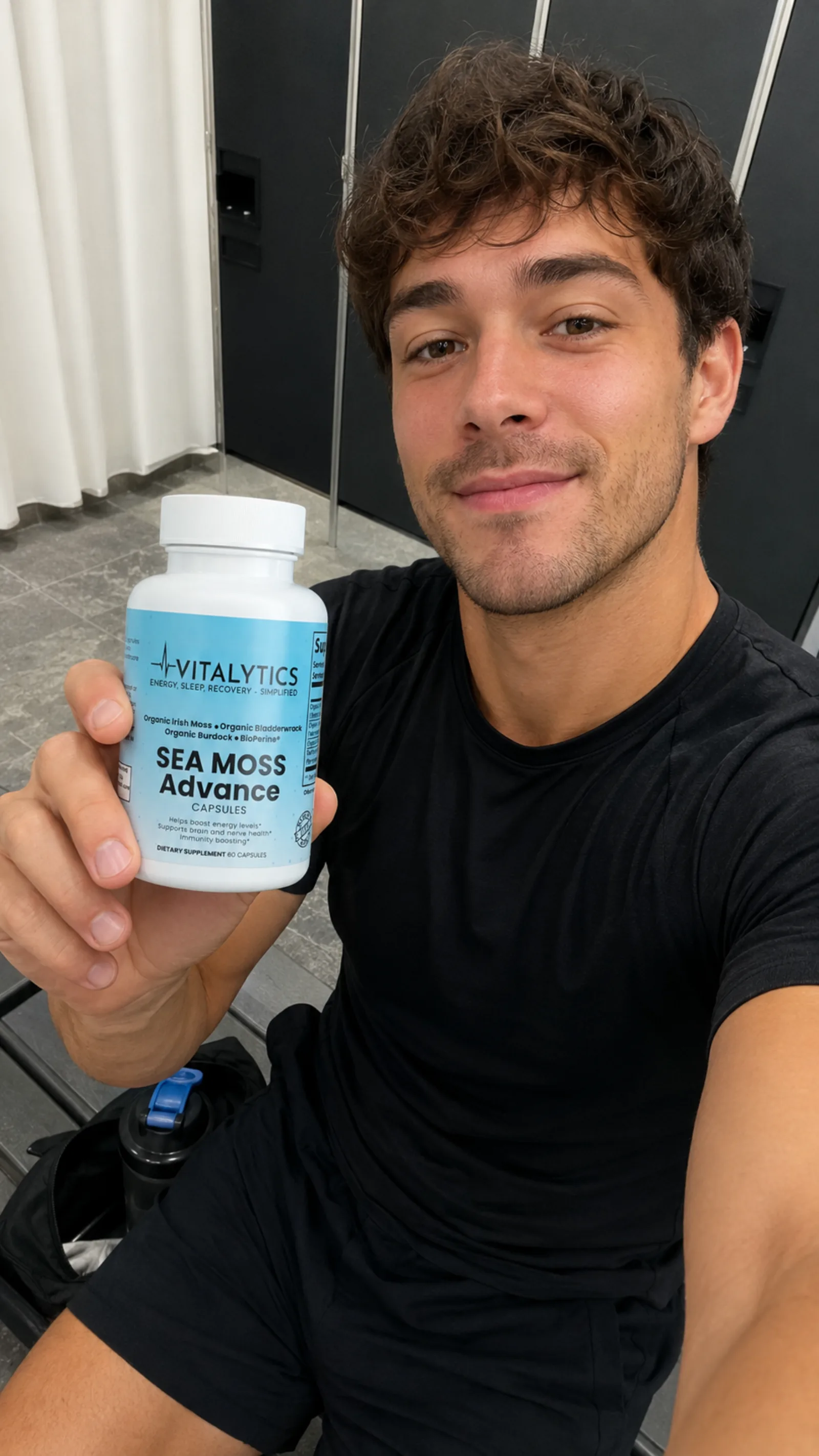Man in a locker room holding Vitalytics Sea Moss Advance in a post-workout selfie.
